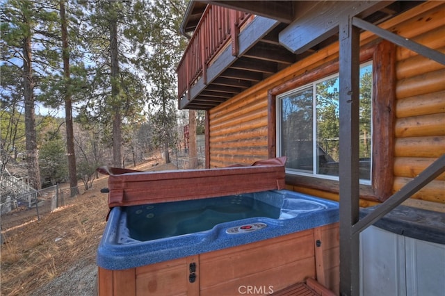 exterior space featuring a hot tub and a balcony