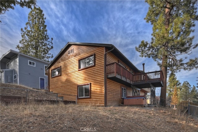 back of house featuring a balcony and a hot tub