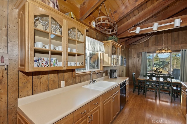 kitchen with sink, wood walls, vaulted ceiling with beams, wood-type flooring, and hanging light fixtures