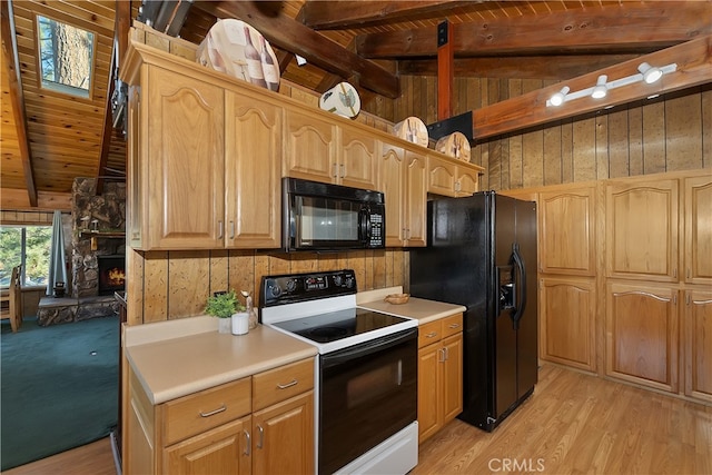 kitchen featuring vaulted ceiling with beams, a stone fireplace, black appliances, and wood walls