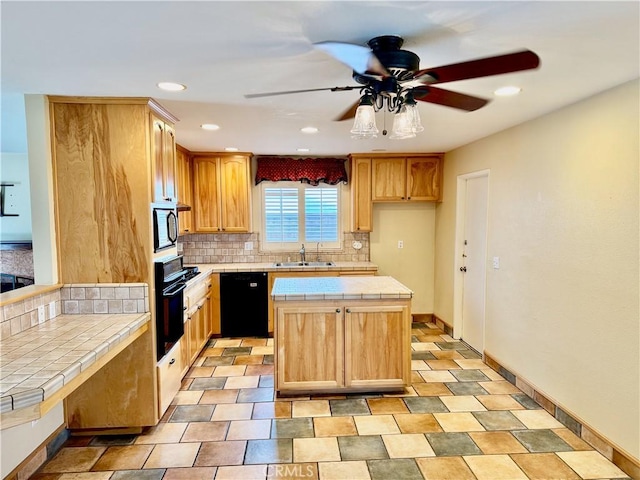 kitchen with tile countertops, backsplash, a kitchen island, a sink, and black appliances