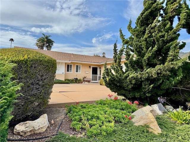 view of front facade featuring a patio area and stucco siding