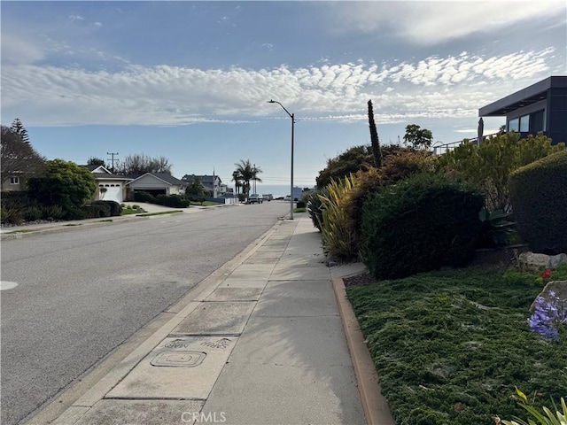 view of street featuring curbs, street lighting, and sidewalks