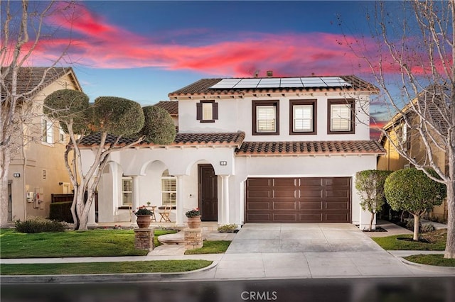 view of front of home with a yard, a garage, and solar panels