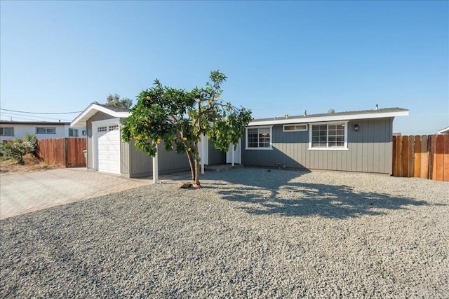 single story home with a garage, fence, and decorative driveway