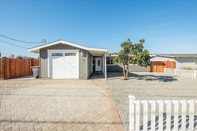 ranch-style house with decorative driveway and fence