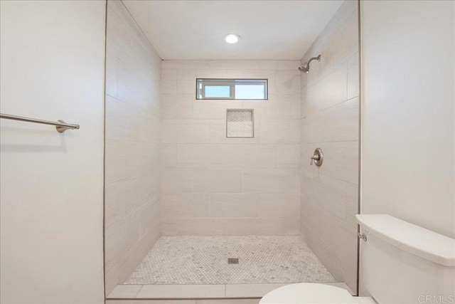 full bath featuring toilet and a tile shower