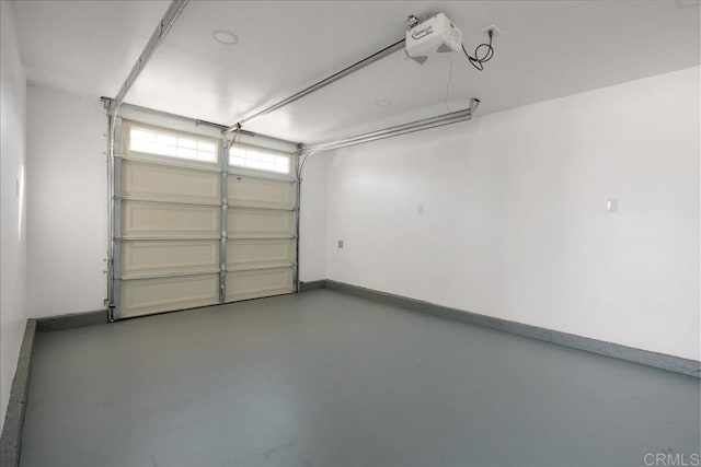 garage featuring a garage door opener and baseboards