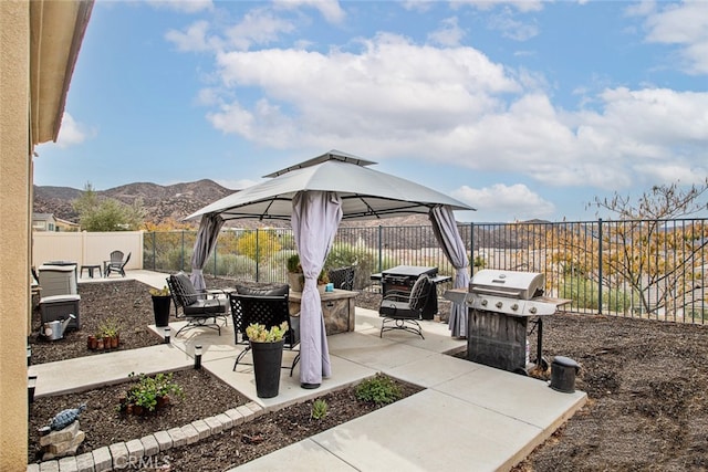 view of patio featuring a mountain view, a gazebo, a grill, and an outdoor fire pit