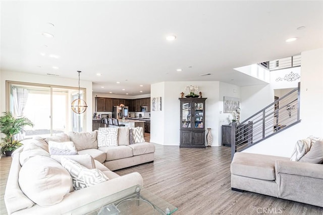 living room featuring an inviting chandelier and light hardwood / wood-style floors