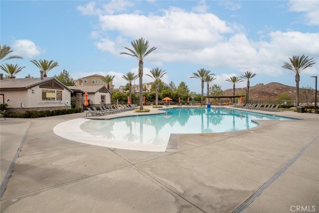 view of pool featuring a mountain view and a patio