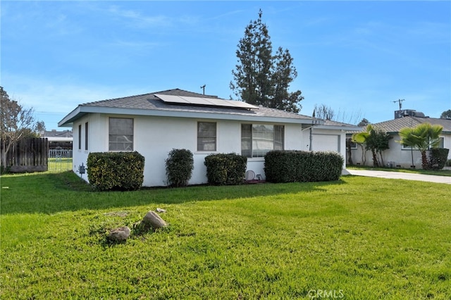 view of side of home with a garage, a lawn, and solar panels