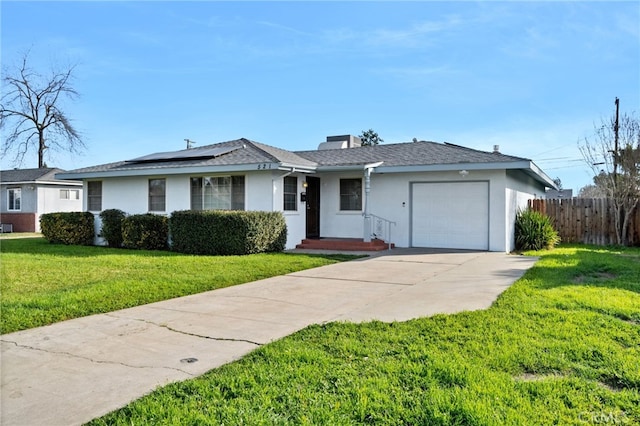 ranch-style home with a garage, a front lawn, and solar panels