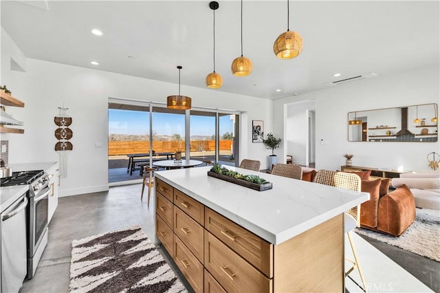 kitchen with a kitchen island, appliances with stainless steel finishes, a breakfast bar, pendant lighting, and light stone countertops