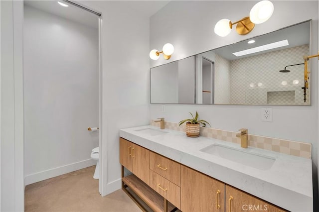 bathroom with a skylight, vanity, and toilet