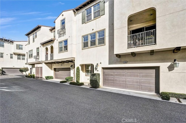 view of front of home with a garage, a residential view, and stucco siding