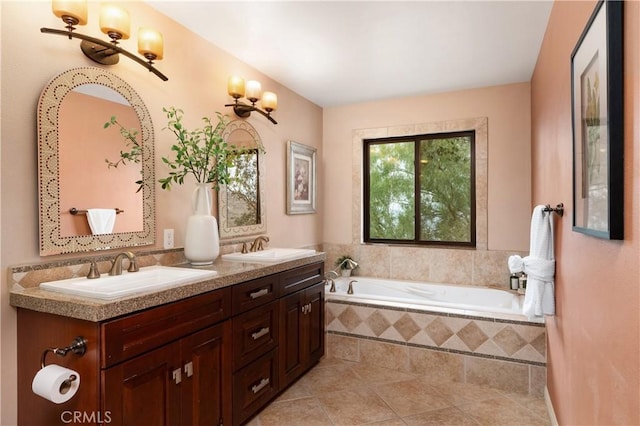 bathroom with tiled tub, vanity, and tile patterned flooring