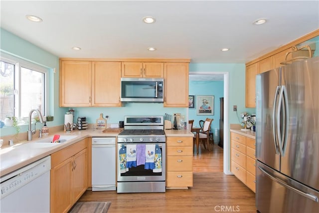 kitchen featuring appliances with stainless steel finishes, light hardwood / wood-style floors, sink, and light brown cabinets