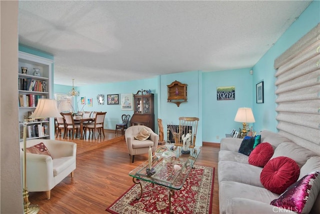 living room featuring wood-type flooring and a textured ceiling