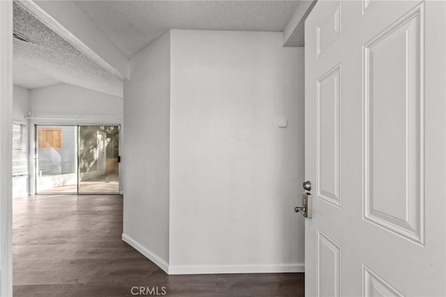 corridor featuring a textured ceiling and dark hardwood / wood-style flooring