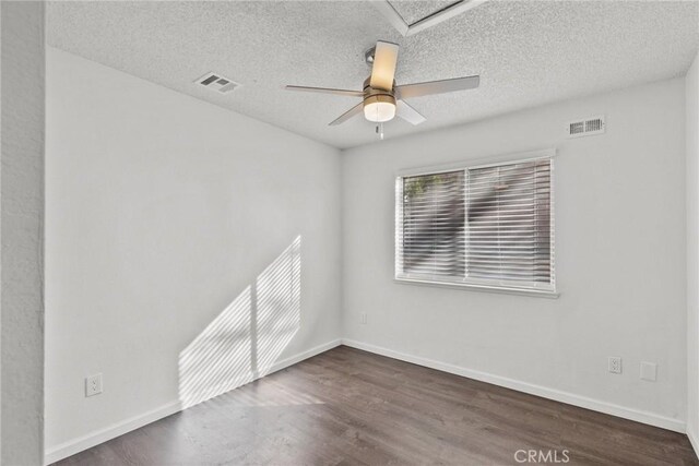 spare room with ceiling fan, dark hardwood / wood-style floors, and a textured ceiling