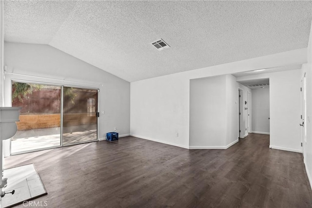 empty room with vaulted ceiling, dark wood-type flooring, and a textured ceiling