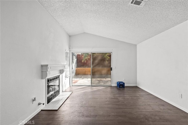 unfurnished living room featuring heating unit, vaulted ceiling, dark hardwood / wood-style floors, and a textured ceiling