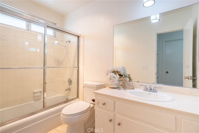 full bathroom featuring vanity, combined bath / shower with glass door, toilet, and tile patterned flooring