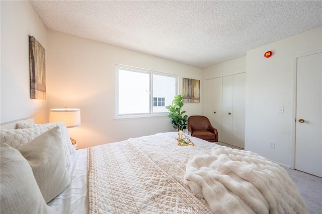 bedroom with a textured ceiling, a closet, and light colored carpet