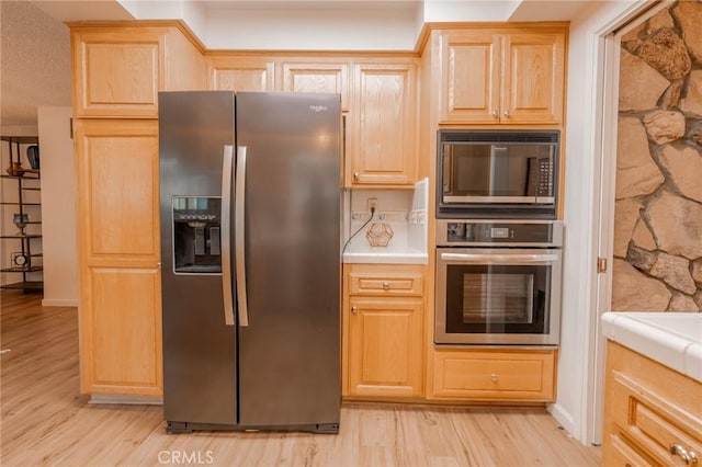 kitchen featuring appliances with stainless steel finishes, light brown cabinets, and light hardwood / wood-style flooring