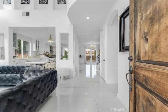 entryway with a notable chandelier, a healthy amount of sunlight, and light tile patterned floors