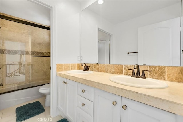 full bathroom with vanity, decorative backsplash, shower / bath combination with glass door, and toilet