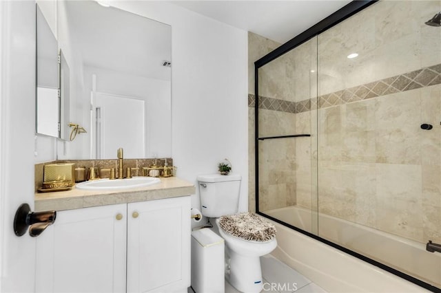 full bathroom featuring vanity, shower / bath combination with glass door, and toilet