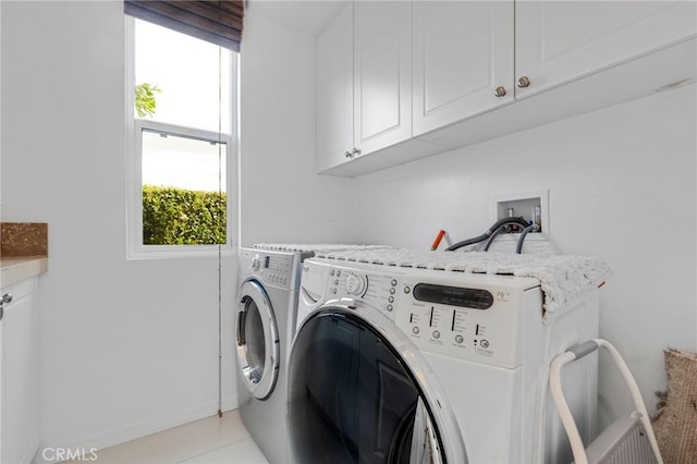 clothes washing area featuring cabinets and washing machine and clothes dryer