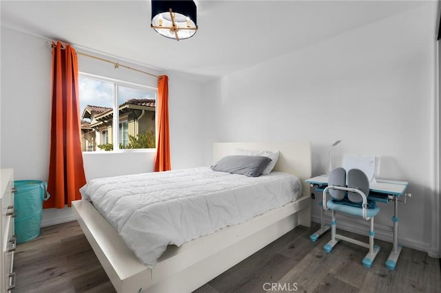 bedroom with dark hardwood / wood-style floors