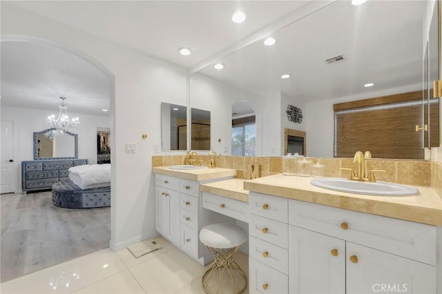 bathroom with tasteful backsplash, vanity, and tile patterned floors