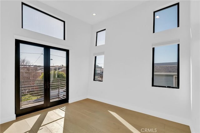 2319 Huntington Ln Unit A, Redondo Beach, CA 90278 - empty room with french doors, a towering ceiling, light wood-style flooring, and recessed lighting