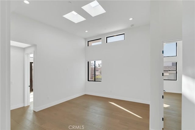 2319 Huntington Ln Unit A, Redondo Beach, CA 90278 - spare room with wood finished floors, a skylight, recessed lighting, and a high ceiling
