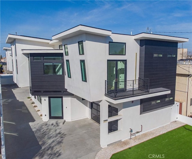 2319 Huntington Ln Unit A, Redondo Beach, CA 90278 - back of house with a balcony, stucco siding, a garage, and driveway