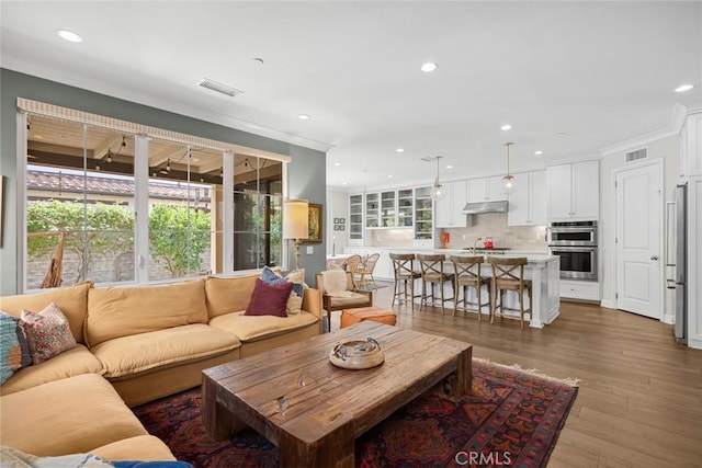 living room with crown molding and wood-type flooring