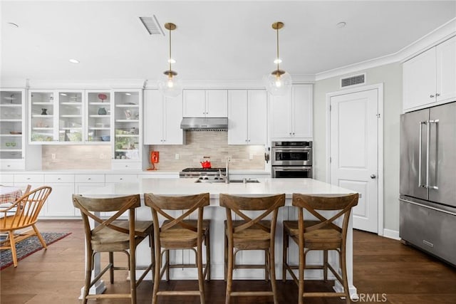 kitchen with stainless steel appliances, sink, pendant lighting, and white cabinets