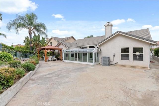 back of house with central AC unit, a gazebo, a patio area, and a sunroom