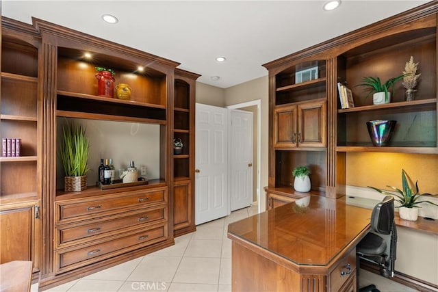 home office with built in desk and light tile patterned flooring