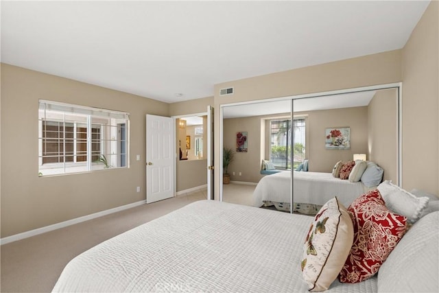 bedroom featuring light colored carpet and a closet