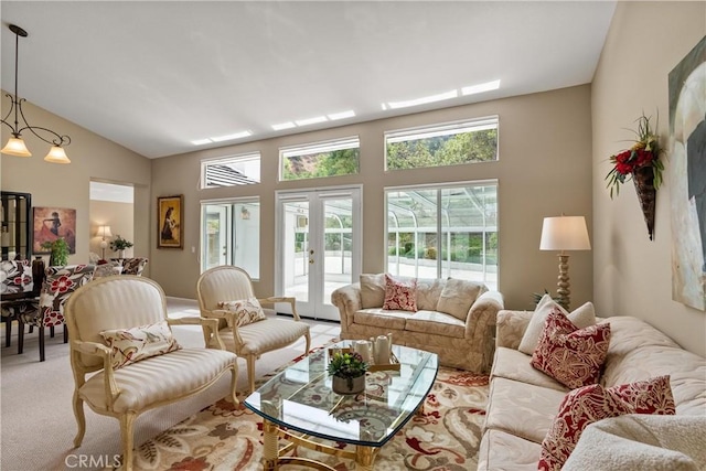 carpeted living room featuring high vaulted ceiling and french doors