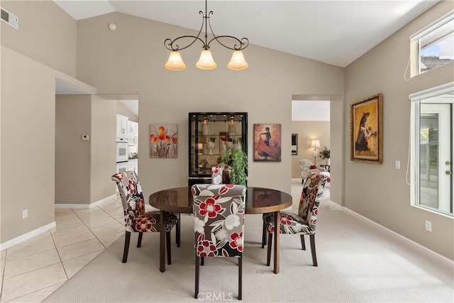 dining room featuring a notable chandelier, lofted ceiling, and light tile patterned floors