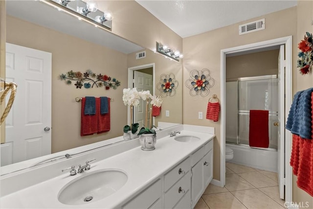 full bathroom featuring tile patterned floors, toilet, combined bath / shower with glass door, and vanity