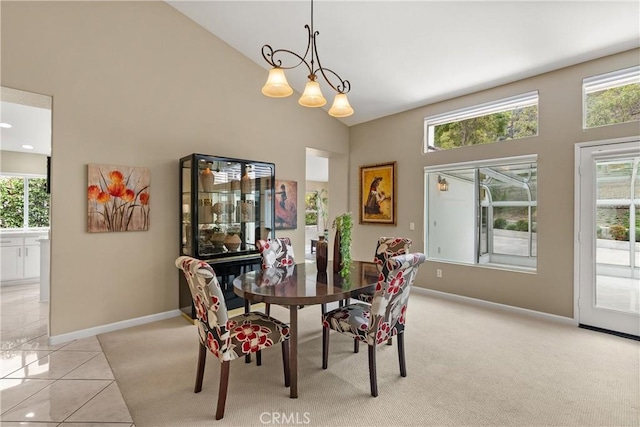 dining room with light tile patterned floors and high vaulted ceiling