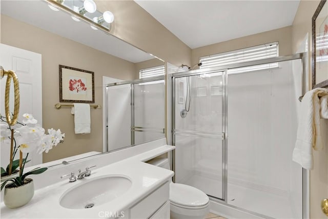 bathroom with a shower with door, vanity, and toilet