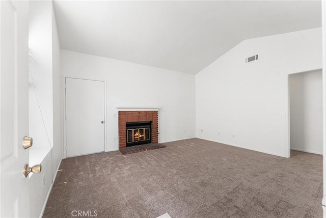 unfurnished living room with visible vents, lofted ceiling, a brick fireplace, and carpet flooring